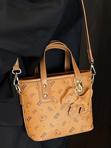 Brown monogram tote bag with bear print, pebble leather texture and crossbody strap