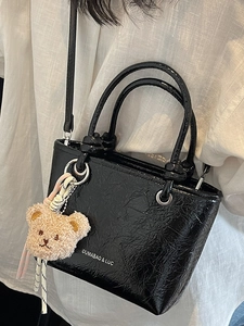 Fashionable black lychee textured tote bag with bear charm and long shoulder strap