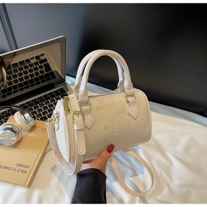 Detailed view of cream Boston bag featuring embossed bear pattern and PU leather texture
