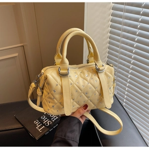 Detail of yellow quilted handbag with sparkling rhinestones and a sturdy top handle