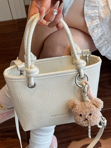 Chic white lychee textured tote bag with shoulder strap and a cute brown bear charm