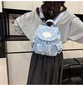Détail du sac à dos fleuri bleu clair avec fermeture à cordon et mini poches vintage