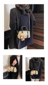 Detailansicht der beige Boston Tasche mit Comic Bär Prints und Plüschbär Anhänger