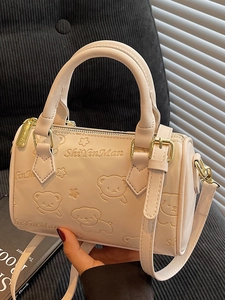 Elegant cream Boston handbag with embossed pet pattern and adjustable gold strap