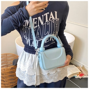 Detail of light blue litchi grain mini bag featuring oversized decorative beads and handle