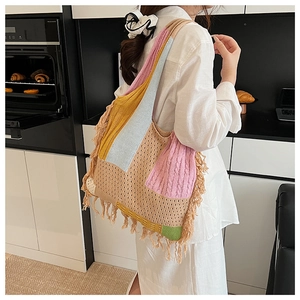 Detail of multi-color knit tote bag with fringe tassels and soft textured stitching