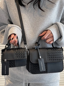 Fashionable retro black tote bag with woven panel and chain strap shown in a hand-held view