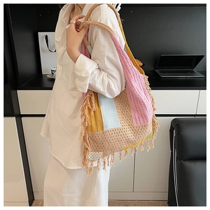 Detail of bohemian crochet tote bag featuring multi-color patchwork and fringe tassels