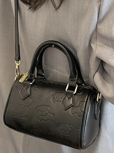 Chic black Boston bag for women featuring embossed cartoon animal patterns and gold hardware