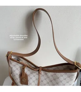 Detail of adjustable strap and clover charm on beige vintage monogram tote bag