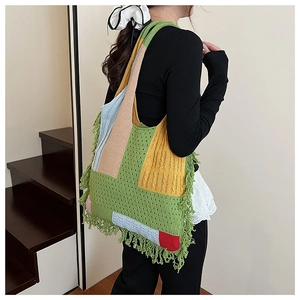 Detail of colorful knitted tote bag with long boho tassels and hollow crochet texture