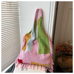 Detail of colorful knit tote bag featuring tassel accents and mixed crochet textures
