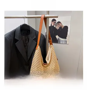 Detail shot of summer straw woven tote bag featuring high-quality brown leather shoulder straps