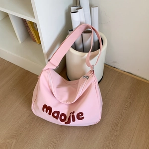 Detail of pink canvas tote bag with adjustable shoulder strap and zip closure