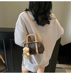 Detail der Boston Bag mit Monogramm-Muster und niedlichem Bären-Anhänger am Schultergurt