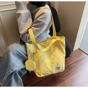 Detail of waterproof yellow nylon tote bag with a small matching round coin purse attached