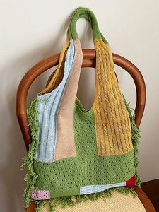 Retro knit tote bag with colorful patchwork, fringe details on a wooden chair