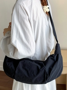 Minimalist black crescent crossbody bag with wide shoulder strap in casual nylon style