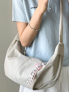 Minimalist cream crescent crossbody bag with pleated texture and wide shoulder strap