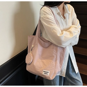 Detail view of large lavender nylon tote bag with a small round coin purse attachment