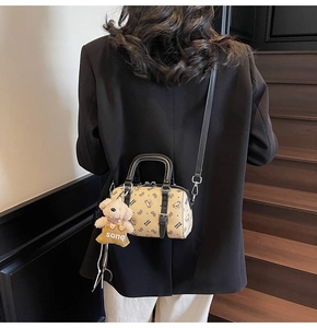 Boston-Tasche mit Bärenprint und Plüsch-Anhänger als Umhängetasche auf schwarzem Blazer