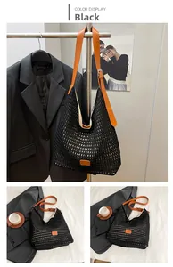Detail of black mesh crochet tote bag featuring vibrant orange leather straps