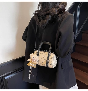 Detailansicht der cremefarbenen Boston Bag mit Bärenmuster über einem schwarzen Blazer