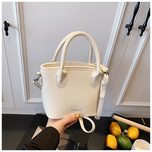 Détail du sac bandoulière blanc cassé avec texture plissée et bandoulière réglable