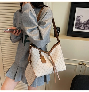 Close-up of beige vintage hobo bag with tassel drawstring and small matching pouch