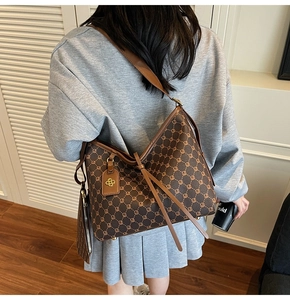 Model wearing a large vintage monogram tote bag in dark brown with a matching pouch