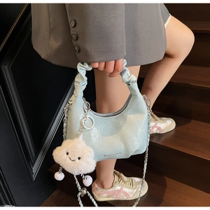 Detail of light blue ruched cloud bag with silver chain and cute white plush pendant