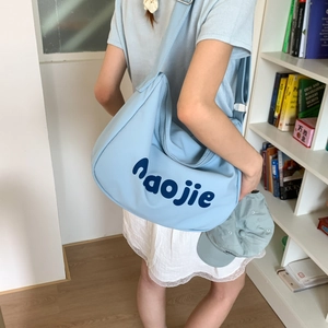 Detail of light blue hobo canvas bag with navy naojie print for casual daily styling