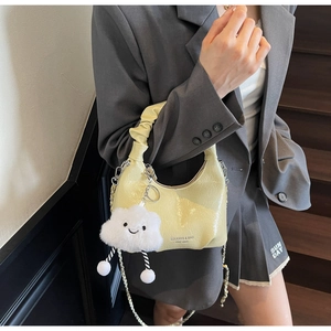 Detail of yellow pleated crescent bag with gold chain strap and fluffy cloud charm