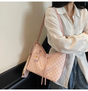 Detailed side view of pink monogram hobo bag with matching mini pouch and gold hardware