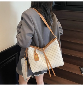 Detail of elegant cream tote bag with vintage pattern and stylish leather tassels