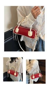 Dettaglio borsa a contrasto rossa e crema con lunghe nappe in pelle e tracolla rimovibile