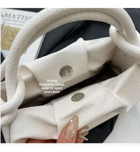Detail of strong magnetic closure on white lychee grain handbag with fabric lining
