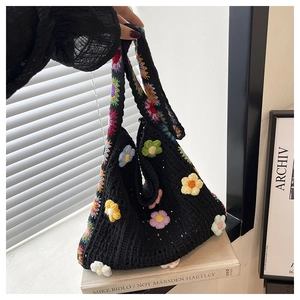 Detailansicht der handgefertigten schwarzen Häkeltasche mit bunten gestrickten 3D-Blumen