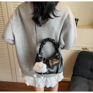 Rear view of black pleated hobo bag with plush cloud charm and metal chain strap