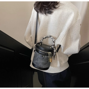 Detail of vintage bucket bag with graffiti scarf handle and gold lock charm