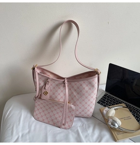 Close-up of pink geometric pattern tote bag with matching pouch and golden hardware