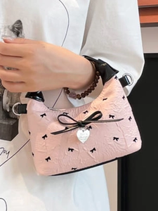Borsa a secchiello rosa con stampe di fiocchi neri e ciondolo a cuore in metallo lucido