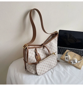 Detail view of retro monogram tote bag with matching pouch and golden floral pendant