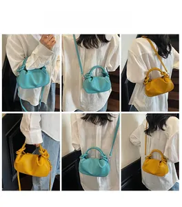 Detail shot of cloud-shaped crossbody bag with twisted knot handle in blue and yellow
