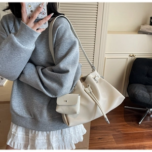 Detail of off-white pleated bucket bag with a matching mini pouch and drawstring closure