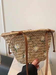 Handwoven straw tote bag with daisy embroidery and leather straps for summer beach
