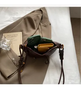 Detail view showing interior capacity of brown leather crossbody bag with daily essentials