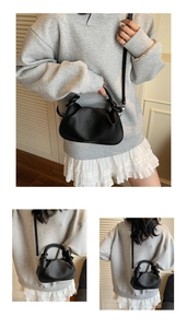 Detail showing black lychee leather cloud bag with knot handle and detachable strap