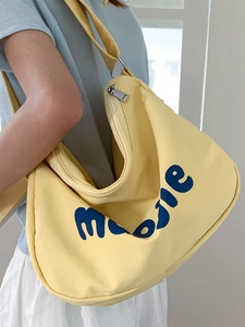Minimalist yellow canvas hobo shoulder bag with blue lettering for casual daily use