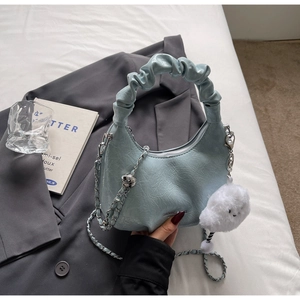 Close-up of ruched light blue crescent bag with silver chain and plush cloud charm
